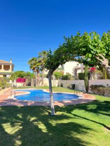 drzewo w ogrodzie obok basenu w obiekcie Impresionante villa PISCINA JARDÍN ALTAONA GOLF w Murcji
