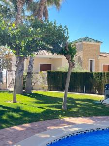 una casa con palmeras y piscina en Impresionante villa PISCINA JARDÍN ALTAONA GOLF, en Murcia