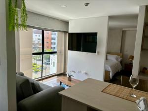 - un salon avec un canapé, un lit et une fenêtre dans l'établissement Apartamento en Zima con aire acondicionado, à Pereira