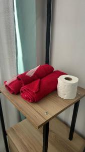 stos czerwonych ręczników i rolka papieru toaletowego w obiekcie Excelente apto na Lapa w mieście Rio de Janeiro