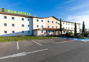 un hôtel avec un parking en face dans l'établissement B&B HOTEL Colmar Lumière, à Colmar