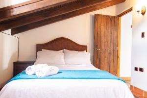a bedroom with a bed with two towels on it at HOTEL ENCANTO COLONIAL in Villa de Leyva