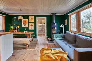 un soggiorno con un divano e un tavolo di Cosy cabin w fireplace 3 mins from Söderåsen Park a Ljungbyhed
