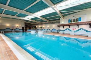 a large indoor swimming pool with blue water at Rutland Hall Hotel in Oakham
