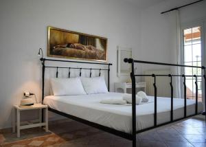 PotamósにあるThalassi Apartment Alykes Potamos Corfuの黒枠のベッド1台が備わるベッドルーム1室