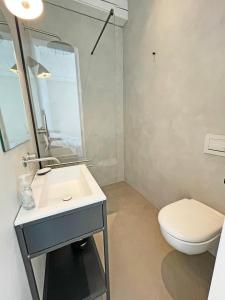 ein Badezimmer mit einem weißen WC und einem Waschbecken in der Unterkunft Kleines Fährhaus in Ulsnis