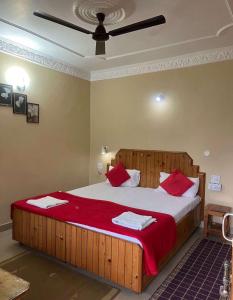 een slaapkamer met een groot houten bed met rode kussens bij Goroomgo Bala Paradise Munsyari - Himalayan View Room in Munsyari