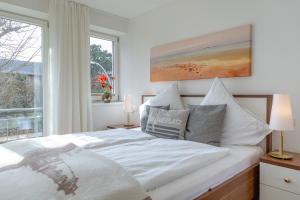 Schlafzimmer mit einem weißen Bett und einem Fenster in der Unterkunft Vik6 10 Viktoria Residenz in Westerland