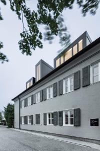 um grande edifício branco com janelas escuras em Lukas Kapeller Hotel und Restaurant em Steyr