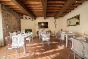 モンテリッジョーニにあるRelais La Costa Historical Residenceの白いテーブルと椅子が備わる広いダイニングルーム