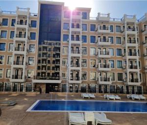 ein großes Gebäude mit einem Swimmingpool davor in der Unterkunft Premium Ferienwohnung SWETI WLAS Polarstar Beach Luxury Apartment 150 m zum Strand Pool 3 Balkone Meeresblick Google TV bis zu 6 Personen in Sweti Wlas
