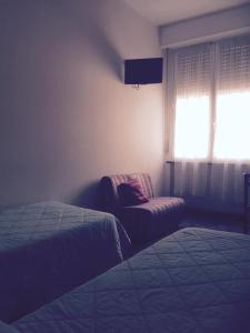 - une chambre avec un lit, une chaise et une fenêtre dans l'établissement Hotel San Marco, à Savone