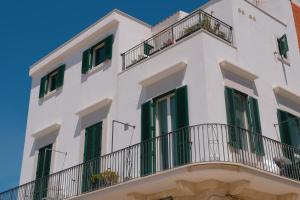 a white building with green shutters and balconies at La Finestrella in Bari