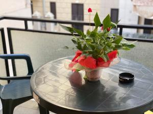 une table avec un vase et une fleur sur elle dans l'établissement Hotel San Marco, à Savone