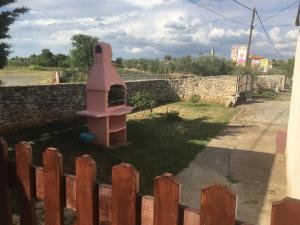 ein rosa Vogelhaus in einem Hof neben einer Ziegelwand in der Unterkunft Vacation Home Elba in Vodnjan