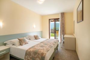 A bed or beds in a room at Residence Dany appartamenti con cucina vista lago piscina e parcheggio