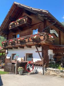 a log cabin with a balcony and flowers on it at Almhütte zwei Welten in Obervellach