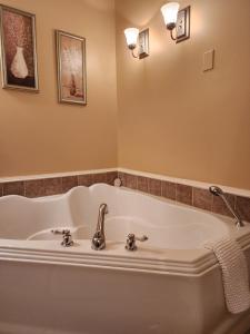 a bath tub with a sink in a bathroom at Auberge les Etchemins in Sainte-Germaine-du-Lac-Etchemin