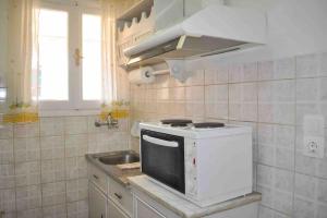 a kitchen with a white stove and a sink at Evdoxia - Piccola Casa Corfu Town in Ágios Rókkos