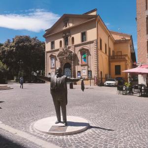 a statue of a man standing in the middle of a street at Il nido di Silvia a due passi dal teatro Rossini in Pesaro