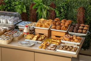 a table with many different types of pastries on it at Cosmopolita Hotel Rome, Tapestry Collection by Hilton in Rome