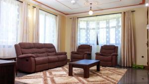 ein Wohnzimmer mit einem Sofa und 2 Stühlen in der Unterkunft Kerith Springs Family Holiday home Bamburi Msa in Bamburi