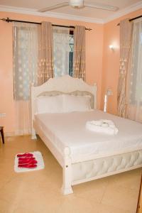 duże białe łóżko w pokoju z oknami w obiekcie Kerith Springs Family Holiday home Bamburi Msa w mieście Bamburi
