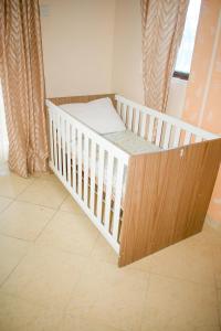 ein Kinderbett in einem Zimmer mit Fenster in der Unterkunft Kerith Springs Family Holiday home Bamburi Msa in Bamburi