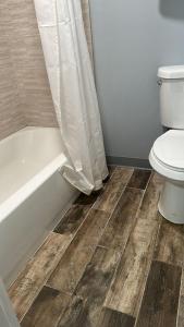 een badkamer met een toilet en een bad met een douchegordijn bij Americas Best Value Inn in East Greenbush