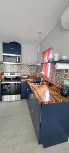 Cute Brand New Home near Tampa Bay-Vicenza Home في ريفرفيو: مطبخ مع خزائن زرقاء وقمة منضدة خشبية