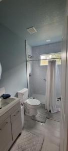 y baño blanco con aseo y ducha. en Cute Brand New Home near Tampa Bay-Vicenza Home, en Riverview