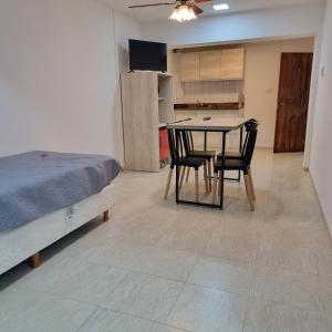 een slaapkamer met een bed en een tafel en stoelen bij ParSur alquileres temporales Catamarca in San Fernando del Valle de Catamarca