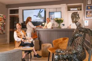 a group of women standing at a counter in a store at Hotel Auberge St. Pol in Knokke-Heist