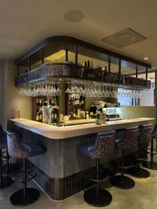 een bar met barkrukken en wijnglazen bij Albus Hotel Amsterdam City Centre in Amsterdam