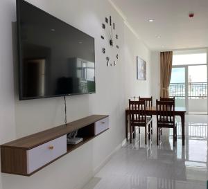 un soggiorno con tavolo da pranzo e TV a schermo piatto di High-class apartment with beautiful river view a Long Xuyen