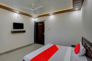una camera con letto e TV a parete di OYO Flagship 81052 Blue Heart Guest House a Ghaziabad