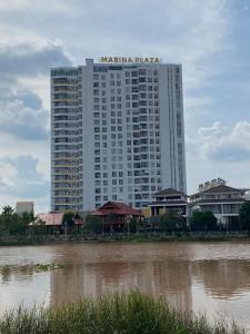 een groot wit gebouw naast een waterlichaam bij High-class apartment with beautiful river view in Long Xuyên