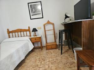sypialnia z łóżkiem, stołem i telewizorem w obiekcie Basic Guardamar pension w mieście Guardamar del Segura