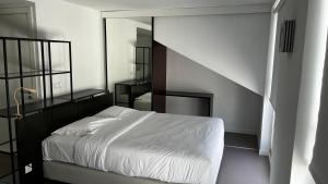 - une chambre avec un lit blanc et un miroir dans l'établissement Oscar Concept Apartments, à Lisbonne