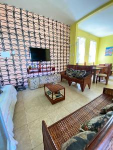 a living room with a couch and a flat screen tv at Hostel Sol da Barra in Salvador