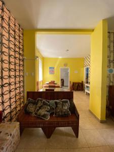 a living room with a couch and a yellow wall at Hostel Sol da Barra in Salvador
