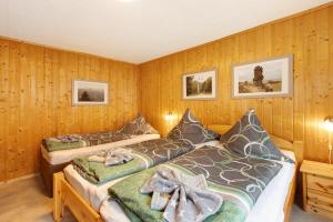 Duas camas num quarto com paredes de madeira em Christels Ferienwohnung 1 In Thale em Thale