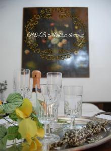 佩爾戈拉的住宿－B&B Antica Dimora，一张桌子,上面放着眼镜和一瓶葡萄酒
