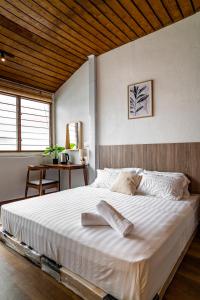 a bedroom with a large white bed with a wooden ceiling at Caryn Vintage Guesthouse in George Town