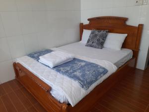 a wooden bed with two pillows on top of it at NGỌC LINH MT in Trung An