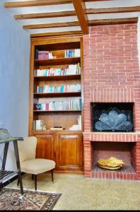a living room with a brick fireplace with a book shelf at B&B Antica Dimora in Pergola