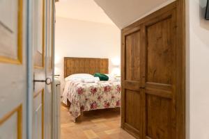 Schlafzimmer mit einem Bett und einer Holztür in der Unterkunft Dilà Assisi Rooms in Assisi