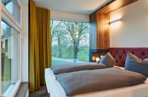 two beds in a room with a large window at Bernsteinland in Wendorf