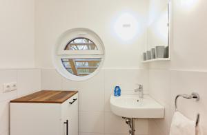 een witte badkamer met een wastafel en een raam bij Bernsteinland in Wendorf