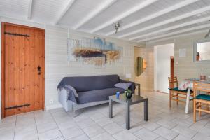 ein Wohnzimmer mit einem blauen Sofa und einem Tisch in der Unterkunft Séjour calme dans une maison avec jardin in Saint-Maixent-sur-Vie